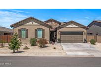 Charming single-story home featuring a stone facade, desert landscaping, and a two-car garage at 18970 W Desert Hills Dr, Surprise, AZ 85388
