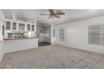 Sun-filled living room featuring neutral carpet, light walls, and open floorplan at 201 S Greenfield Rd # 129, Mesa, AZ 85206