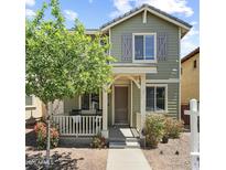 Charming two-story home with a cozy front porch, green siding, and well-maintained landscaping at 2941 N Evergreen St, Buckeye, AZ 85396