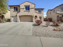Two story home with a three car garage, desert landscaping and a covered front porch at 30271 W Crittenden Ln, Buckeye, AZ 85396
