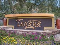 Community sign for Toscana of Desert Ridge with colorful flowers and plants around its base at 5450 E Deer Valley Dr # 1201, Phoenix, AZ 85054