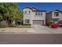 Charming two-story home featuring a front yard with a two-car garage and a neutral-colored stucco facade at 5734 W Gwen St, Laveen, AZ 85339