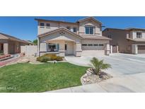 Charming two-story home with lush front yard landscaping and a two car garage featuring a desert color palette at 7670 W Sands Dr, Peoria, AZ 85383