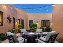 Inviting courtyard features comfortable seating around a cozy fire pit beneath the evening sky at 13450 E Via Linda St # 1019, Scottsdale, AZ 85259