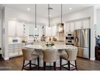 Bright kitchen boasts a large island with seating, stainless steel appliances, and ample cabinet space at 13450 E Via Linda St # 1019, Scottsdale, AZ 85259