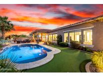 Spacious backyard with a sparkling pool, lush grass and a covered patio for outdoor enjoyment at 29635 N 122Nd Dr, Peoria, AZ 85383