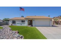 Charming single-story home featuring an American flag, rock landscaping, and a well-maintained lawn at 4621 E Mineral Rd, Phoenix, AZ 85044