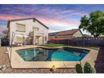 Inviting backyard with a sparkling pool, patio seating, and lush landscaping at 567 E Bradstock Way, Queen Creek, AZ 85140