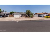 Cozy single-story home featuring a two-car garage, desert landscaping, and a brick-accented facade at 6110 E Ivyglen St, Mesa, AZ 85205