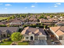 Expansive aerial view of a beautiful suburban home in a well-maintained neighborhood with mountain views in the distance at 3574 E Tonto Pl, Chandler, AZ 85249