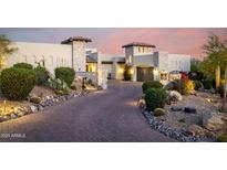 Elegant stucco home with a paved driveway and lush desert landscaping for enhanced curb appeal at 36075 N Summit Dr, Cave Creek, AZ 85331
