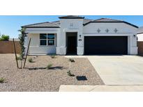 Charming single-story home featuring a black garage door and a well-maintained gravel front yard at 5064 E Midnight Star Dr, San Tan Valley, AZ 85143