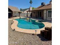 Backyard swimming pool with a hot tub, rock landscaping, and covered patio offers a great space for outdoor entertaining at 12512 N 85Th Ave, Peoria, AZ 85381