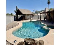A sparkling pool with a covered lounge area offers a relaxing outdoor oasis in this backyard at 12512 N 85Th Ave, Peoria, AZ 85381