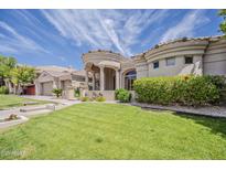 Stunning stucco home featuring a manicured lawn and a circular entryway with prominent columns at 16441 S Mountain Stone Trl, Phoenix, AZ 85048