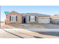 Charming single-story home showcasing stone accents, gray shutters, tile roof, and a paved driveway at 18840 N 269Th Ave, Buckeye, AZ 85396