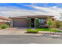 Charming home featuring a well-manicured lawn, mature shrubs, and a brick-paved driveway leading to a two-car garage at 20839 E Kingbird Dr, Queen Creek, AZ 85142