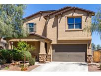 Charming two-story home features a tan stucco exterior and a two-car garage at 21412 W Hubbell St, Buckeye, AZ 85396