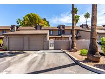Attractive townhome exterior with private garage and gated courtyard entrance and mature landscaping at 2232 W Lindner Ave # 20, Mesa, AZ 85202