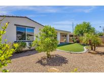 Backyard featuring low-maintenance landscaping, including gravel, plants, and a glimpse of the covered patio at 22472 E Sonoqui Blvd, Queen Creek, AZ 85142