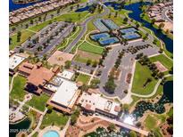 Aerial view of a vibrant community with pools, tennis courts, and manicured green spaces at 42318 W Abbey Rd, Maricopa, AZ 85138