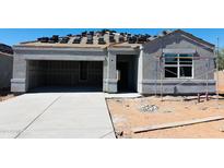 Unfinished gray home featuring an attached two-car garage, covered porch, and stacked roof tiles at 5106 E Midnight Star Dr, San Tan Valley, AZ 85143
