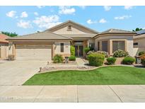 Beautiful single-story home featuring a two-car garage, lush lawn, and stone accents at 8046 W Yukon Dr, Peoria, AZ 85382