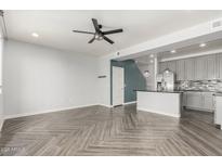 Open-concept living room and kitchen featuring stylish gray cabinets, modern lighting, and herringbone floors at 1056 N Miller Rd, Tempe, AZ 85288