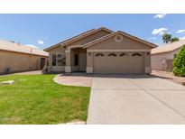 Charming single-story home with a well-manicured lawn and a two-car garage at 137 W Del Rio St, Gilbert, AZ 85233