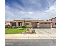 A sprawling ranch-style home boasts a three-car garage, desert landscaping, and a tile roof, adding to its curb appeal at 18249 W Mauna Loa Ln, Surprise, AZ 85388