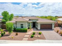 Stunning single-story home featuring a well-manicured front yard and a two-car garage with brick paver driveway at 30909 N 27Th Ave, Phoenix, AZ 85085