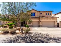 Two-story home featuring a three-car garage, stone accents, and a beautiful desert landscaped front yard at 31604 N 19Th Ave, Phoenix, AZ 85085