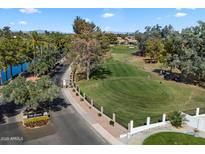 Scenic view of a golf course and community entrance with lush landscaping and a lake at 3671 S Greythorne Way, Chandler, AZ 85248