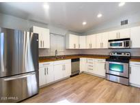 Bright kitchen features stainless appliances, wood-look floors and white cabinets at 1219 E Colter St # 8, Phoenix, AZ 85014