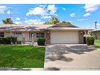 Charming single-story home with a well-manicured lawn and a two-car garage at 15438 N Lakeforest Dr, Sun City, AZ 85351