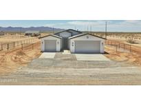 Charming single-story home with a symmetrical facade, two-car garage, and desert landscaping at 25893 W Running Deer Trl, Wittmann, AZ 85361