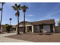 Charming single-Gathering home featuring a two-car garage, desert landscaping, and palm trees at 702 W Sequoia Dr, Phoenix, AZ 85027