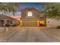 Charming two-story home featuring a spacious driveway, two-car garage, and manicured desert landscaping at 14010 N 126Th Ave, El Mirage, AZ 85335
