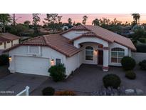 Charming single-story home featuring a brick-paved driveway and lovely landscaping in the front yard at 14248 N 56Th Pl, Scottsdale, AZ 85254