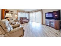 Bright living room featuring hardwood floors, large windows, and comfortable seating at 17404 N 99Th Ave # 318, Sun City, AZ 85373