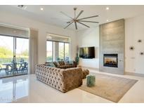 Bright living room features a stone fireplace, large ceiling fan, and glass doors to the outdoor living space at 2106 E Beth Dr, Phoenix, AZ 85042