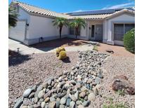 Inviting home exterior boasts solar panels, desert landscaping, and palm trees at 238 W Marco Polo Rd, Phoenix, AZ 85027