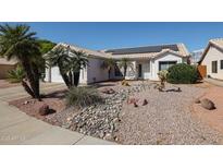 Charming single-story home with desert landscaping and solar panels on the roof at 238 W Marco Polo Rd, Phoenix, AZ 85027