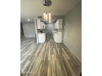 Bright kitchen features sleek white cabinets, modern lighting, and stylish wood-look floors at 6041 W Golden Ln, Glendale, AZ 85302