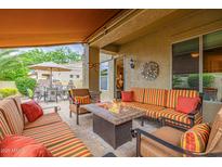 Comfortable covered patio with stylish seating, a fire pit, and views of the manicured outdoor dining area at 6202 E Mckellips Rd # 189, Mesa, AZ 85215