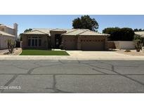 Charming single-story home featuring a tile roof, a three-car garage, and manicured front lawn at 6821 W Donald Dr, Glendale, AZ 85310