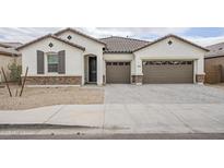 Charming single-story home with a three-car garage, desert landscaping, and a beautiful tile roof at 7531 W Odeum Ln, Phoenix, AZ 85043