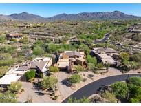Stunning aerial view of desert home with mountain backdrop and mature landscaping at 9998 E Taos Dr, Scottsdale, AZ 85262