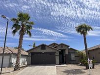Charming single-story home with a desert landscape, palm trees, and a two-car garage at 3229 W Five Mile Peak Dr, San Tan Valley, AZ 85144