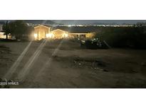 Night view of a home's exterior featuring illuminated details and a distant cityscape at 34047 N 10Th St, Phoenix, AZ 85085